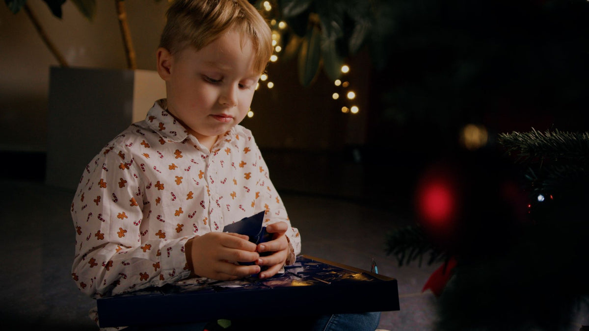 Kind das ein Türchen des Adventskalenders öffnet